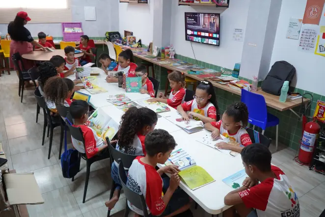 Crianças lendo livros no programa de reforço escolar